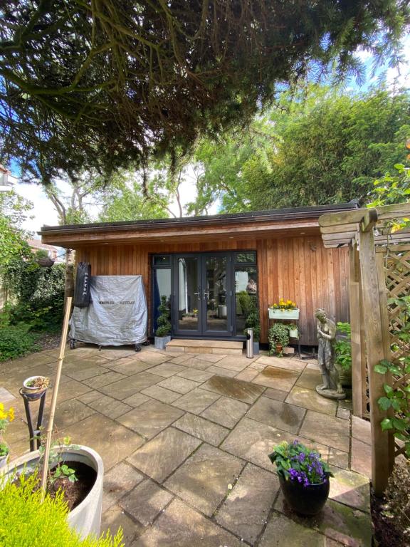 eine Terrasse vor einem Haus mit einem Gebäude in der Unterkunft Thistle Lodge - Quiet Garden lodge with off road parking in Hemel Hempstead