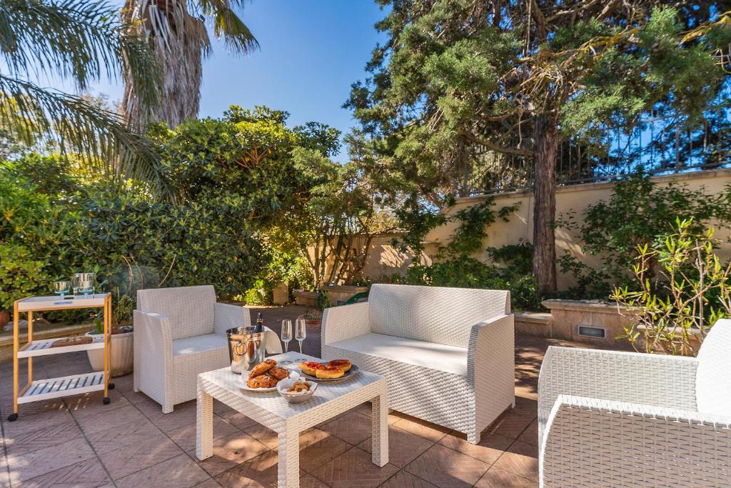 un patio con due sedie e un tavolo con cibo sopra di Garden view near the sea a Lecce