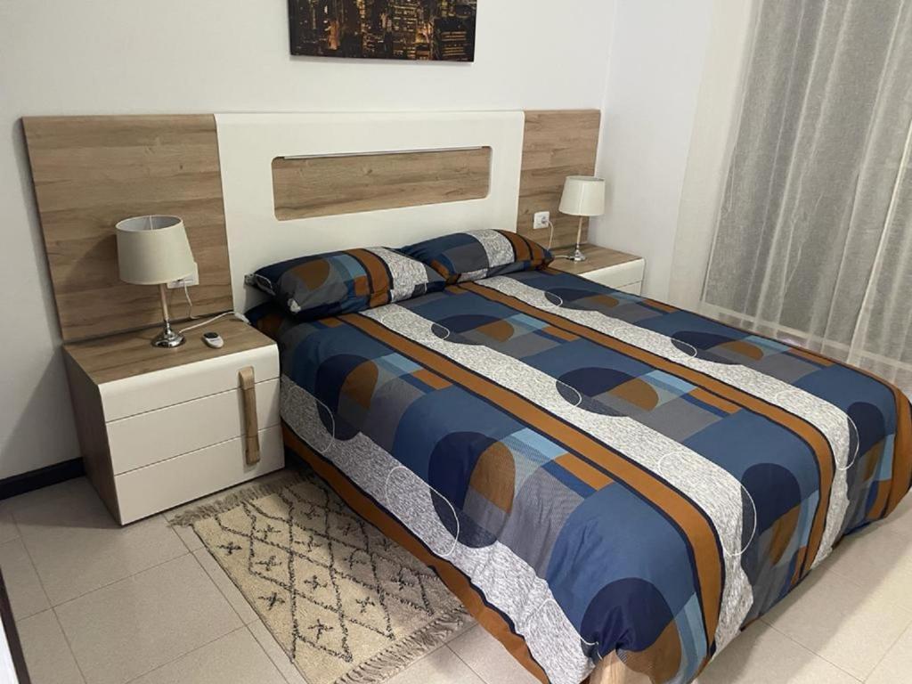 a bed in a bedroom with two night stands and two lamps at Vacacional Arbelo Golf in San Miguel de Abona