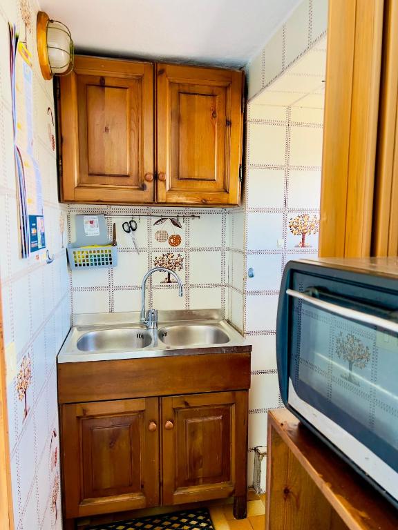 małą kuchnię ze zlewem i kuchenką mikrofalową w obiekcie domus Verde w mieście Ischia