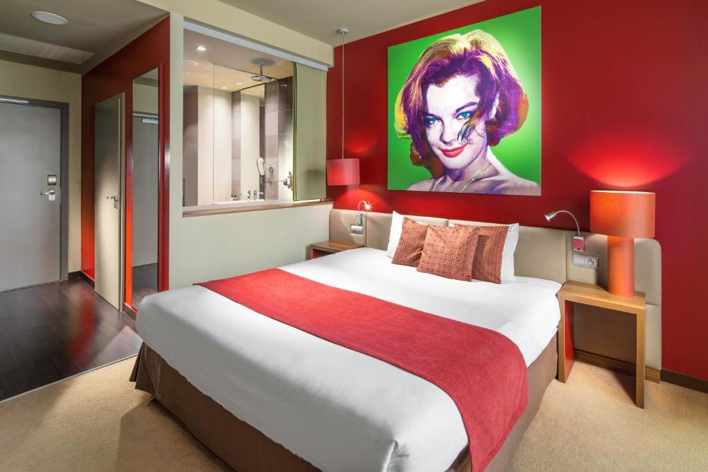 a bedroom with a large bed with a painting on the wall at Clarion Congress Hotel Bratislava in Bratislava