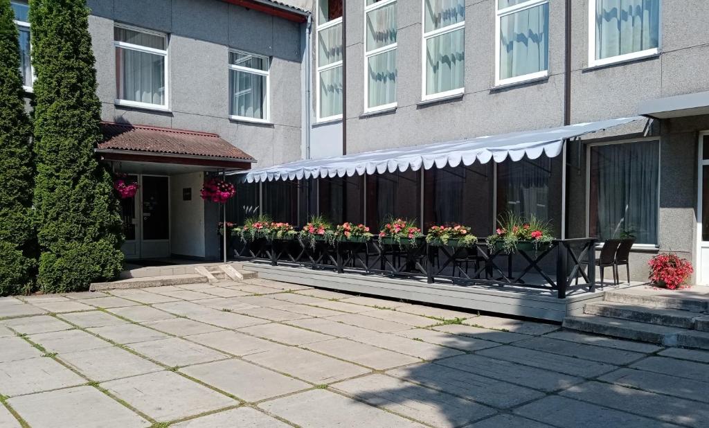 um edifício com uma fila de caixas de flores numa varanda em Gamma Hotel em Līvāni