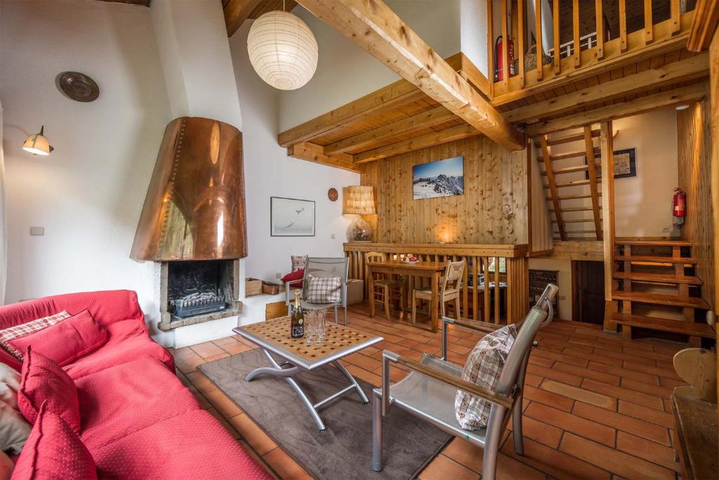 ヴァル・ディゼールにあるMadame Vacances Chalet Val Rogoneyのリビングルーム(赤いソファ、暖炉付)
