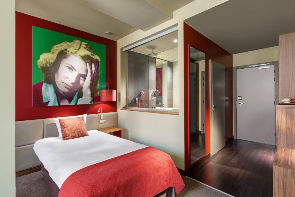 a bedroom with a bed with a painting on the wall at Clarion Congress Hotel Bratislava in Bratislava
