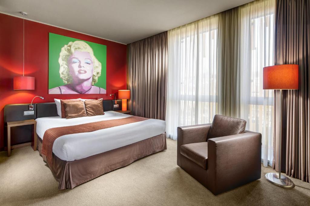 a bedroom with a large bed and a chair at Clarion Congress Hotel Bratislava in Bratislava