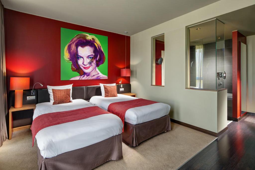 a hotel room with two beds and a painting on the wall at Clarion Congress Hotel Bratislava in Bratislava