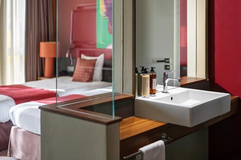 a bathroom with a sink and a bed at Clarion Congress Hotel Bratislava in Bratislava