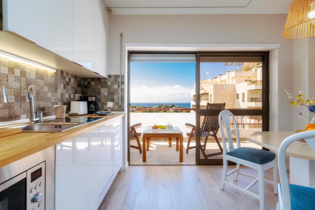 a kitchen with a table and a view of the ocean at Ocean view apartment in Portimão