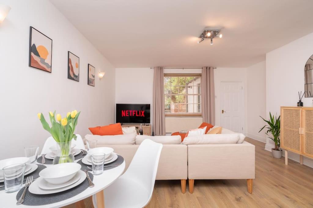 ein Wohnzimmer mit einem weißen Sofa und einem Tisch in der Unterkunft Content-Living in Cheltenham