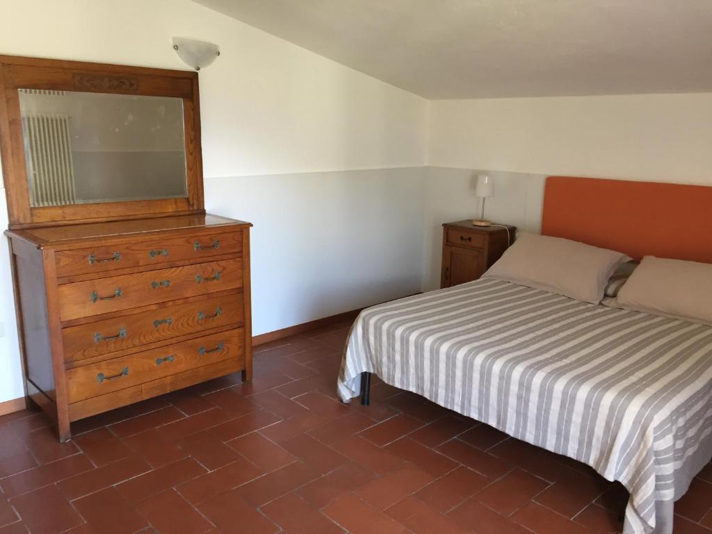 a small bedroom with a bed and a dresser at Villa Eden jacuzzi pool & private parking in Domaso