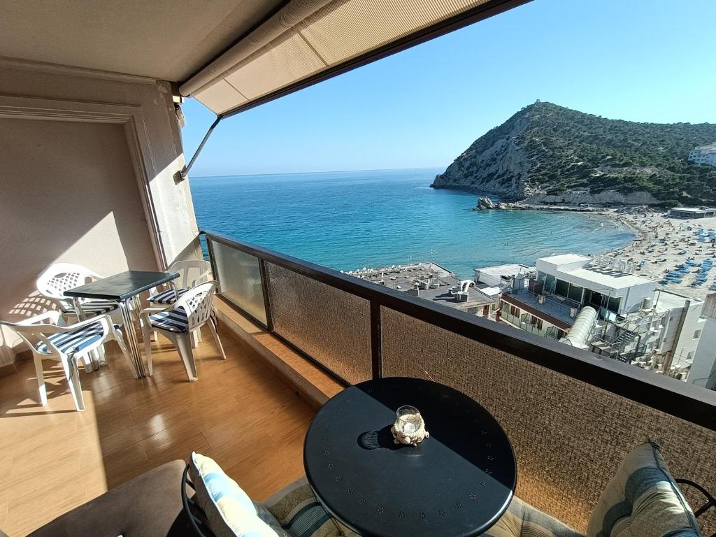 balcón con mesa y vistas al océano en Apartamento en Cala de Finestrat en Cala de Finestrat