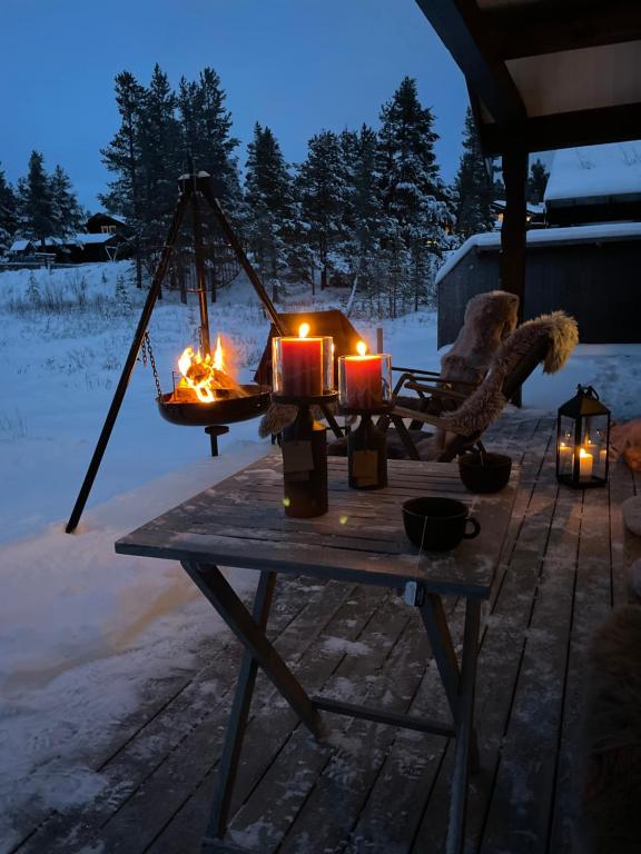 a wooden table with candles on it in the snow at Hytte i nydelige Jotunhemen - rett ved Besseggen in Randsverk