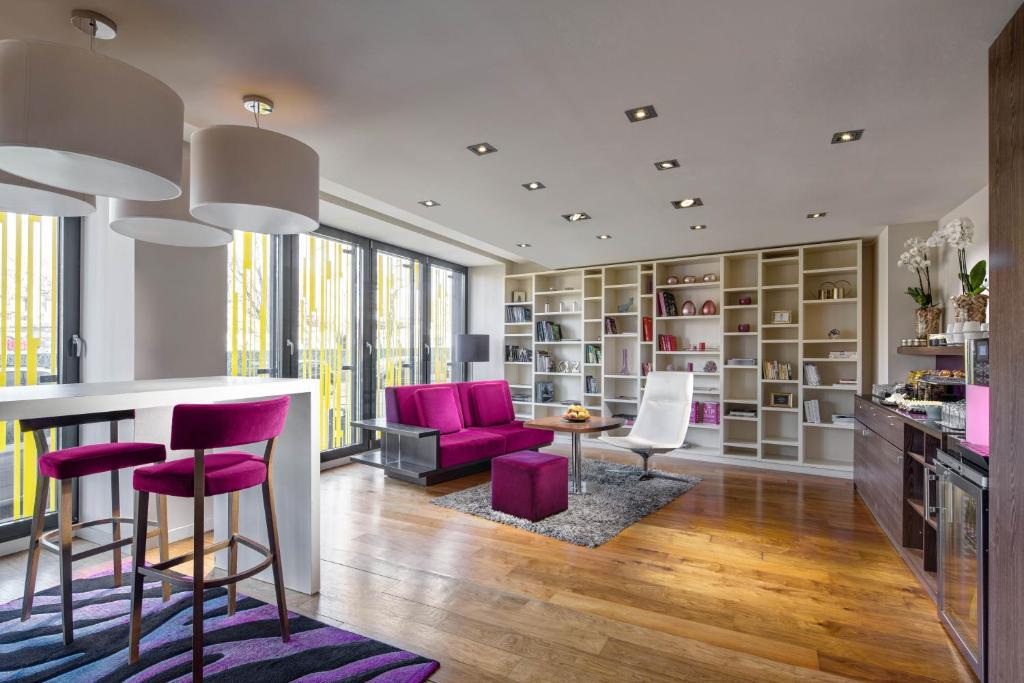 a living room with purple chairs and a table at Clarion Congress Hotel Bratislava in Bratislava