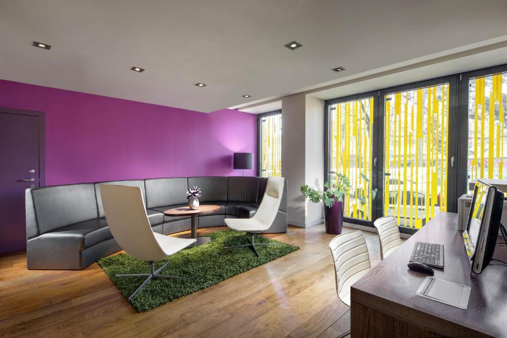 a living room with a couch and a table and chairs at Clarion Congress Hotel Bratislava in Bratislava