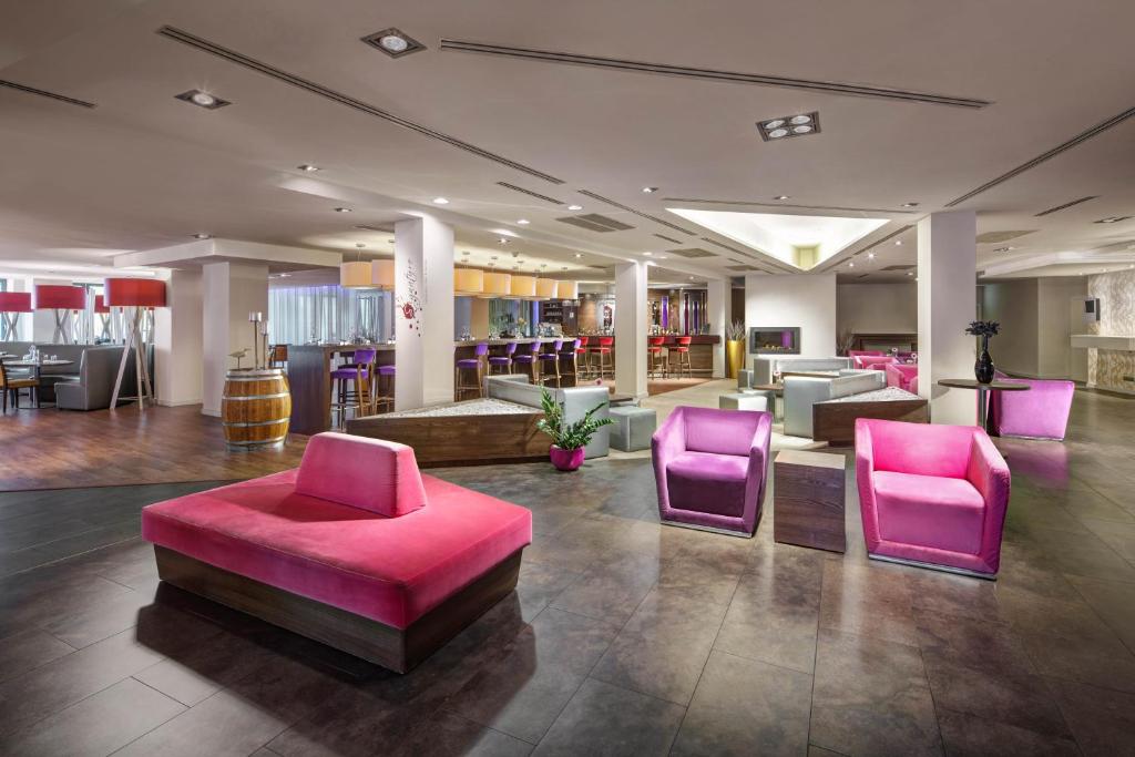 a lobby with pink and purple chairs and tables at Clarion Congress Hotel Bratislava in Bratislava