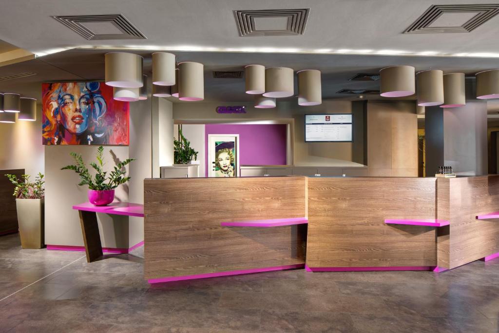 a lobby with a reception desk with pink furniture at Clarion Congress Hotel Bratislava in Bratislava