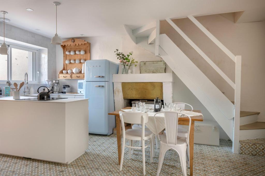 a kitchen with a table and a white refrigerator at Ty Maria Havre de douceur et de calme au coeur de la ville haute de Pornic in Pornic