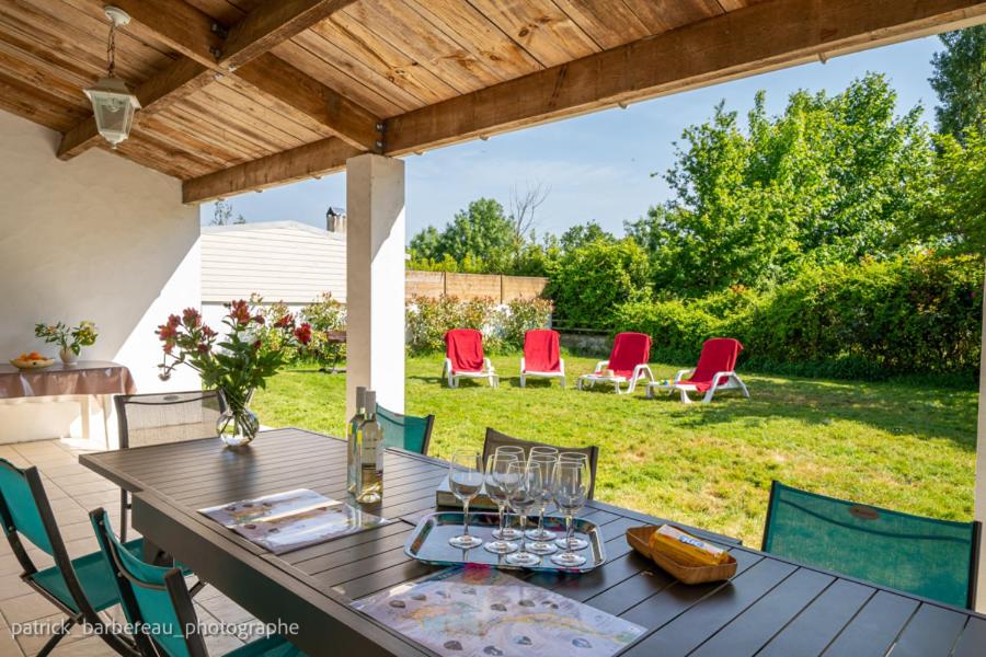 une table et des chaises en bois sur une terrasse dans l'établissement Les Gîtes de Sophie 85 Gîte Hortensia, à Saint-Gervais