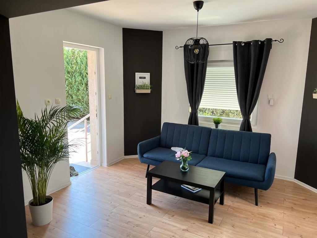 a living room with a blue couch and a table at 4 STARS ROOMS Near Airport in Ščitarjevo