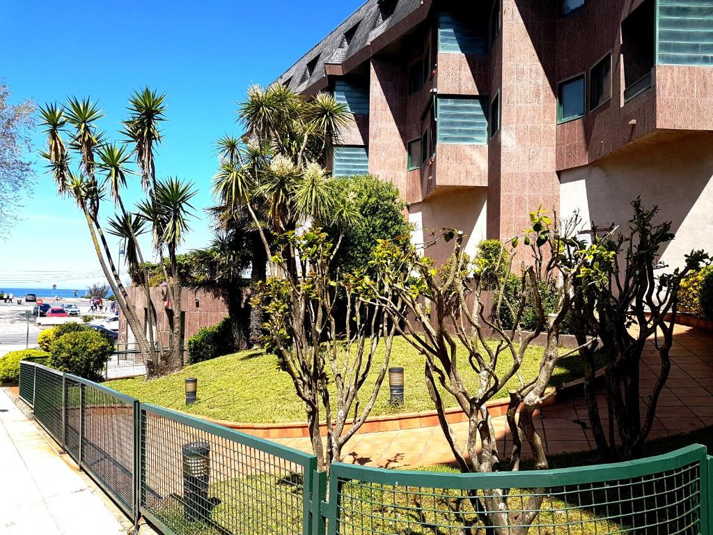 een hek voor een gebouw met palmbomen bij Playa Samil Vigo Reformado 2016 in Vigo