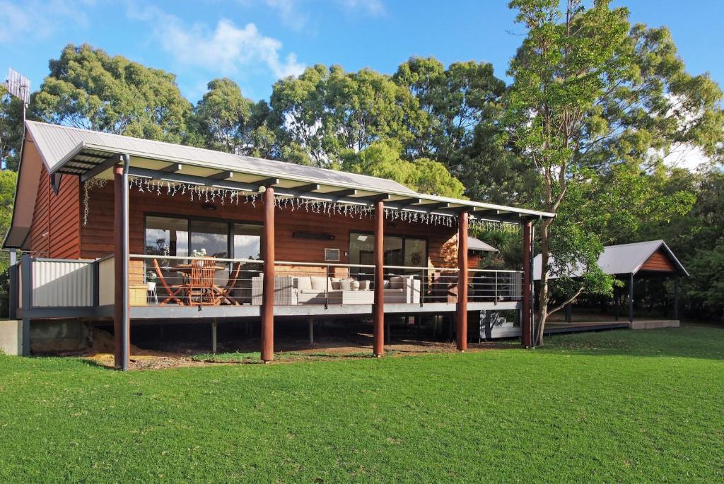 a house with a porch and a grass field at Chalet on Percheron in Margaret River Town