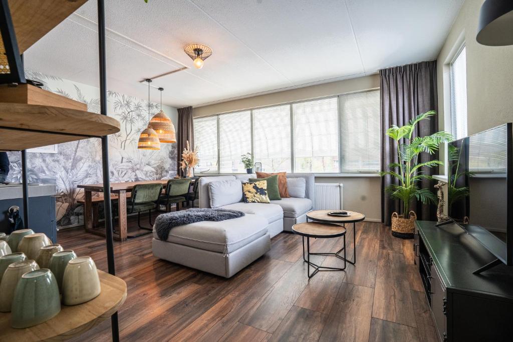 uma sala de estar com um sofá e uma mesa em The Lion King - 6 Person linked apartment with roof terrace em Groningen