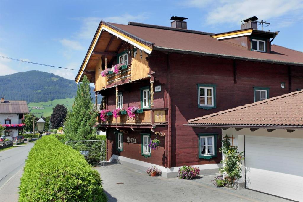 a large brown house with flowers on the balconies at Appartement Wurzrainer in Westendorf