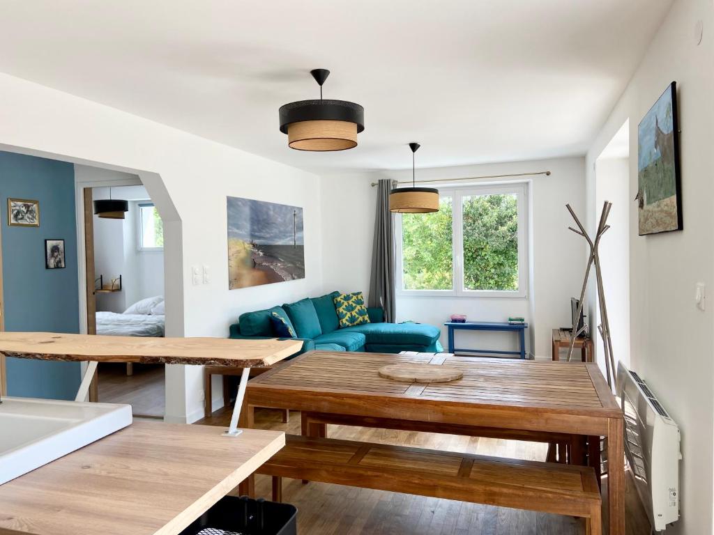 a living room with a table and a blue couch at aux quatre vents in Bénodet