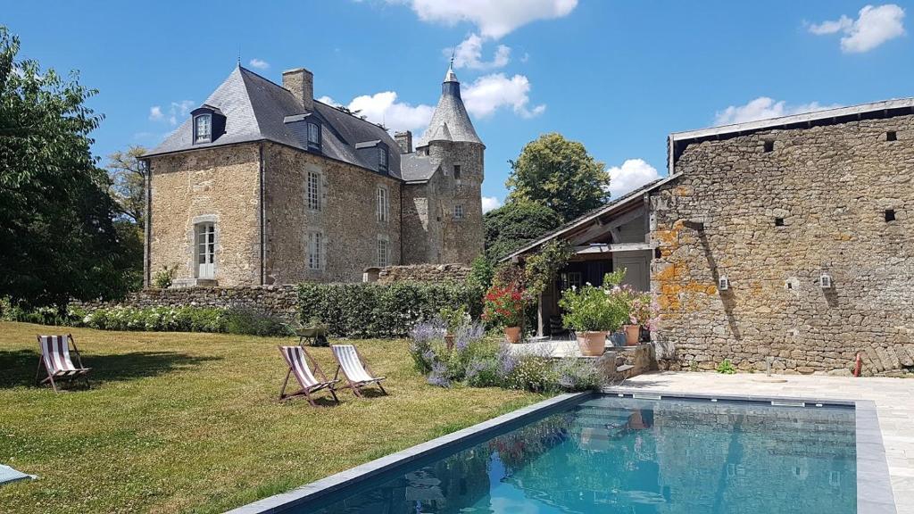 una casa con piscina di fronte a un edificio di L'annexe du Plessis Bochard a Saint-Pierre-des-Nids