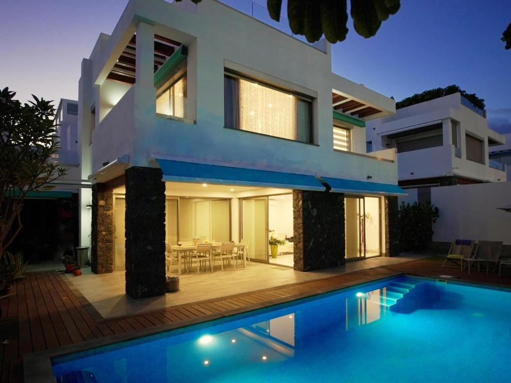 a house with a swimming pool in front of it at Villa BLUE PORTOFINO Los Cristianos, POOL in Los Cristianos