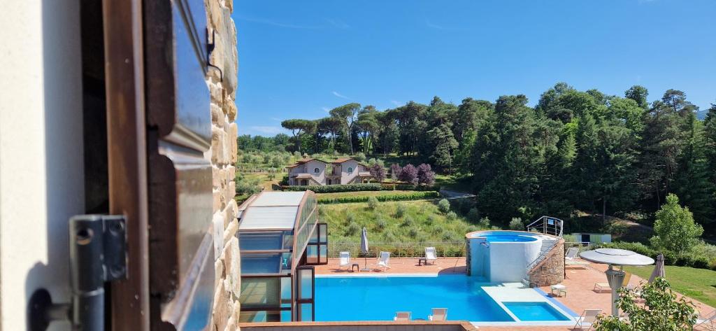 uma vista para uma piscina a partir de uma janela em B&B Podere Montese em Villafranca in Lunigiana