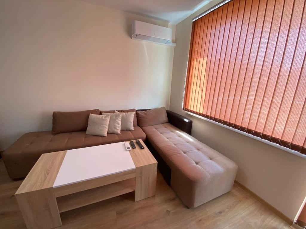 a living room with a couch and a coffee table at Апартамент SUMI in Varna City