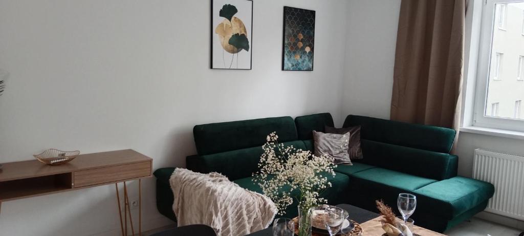 a living room with a green couch and a table at Tabago Studio in Opole