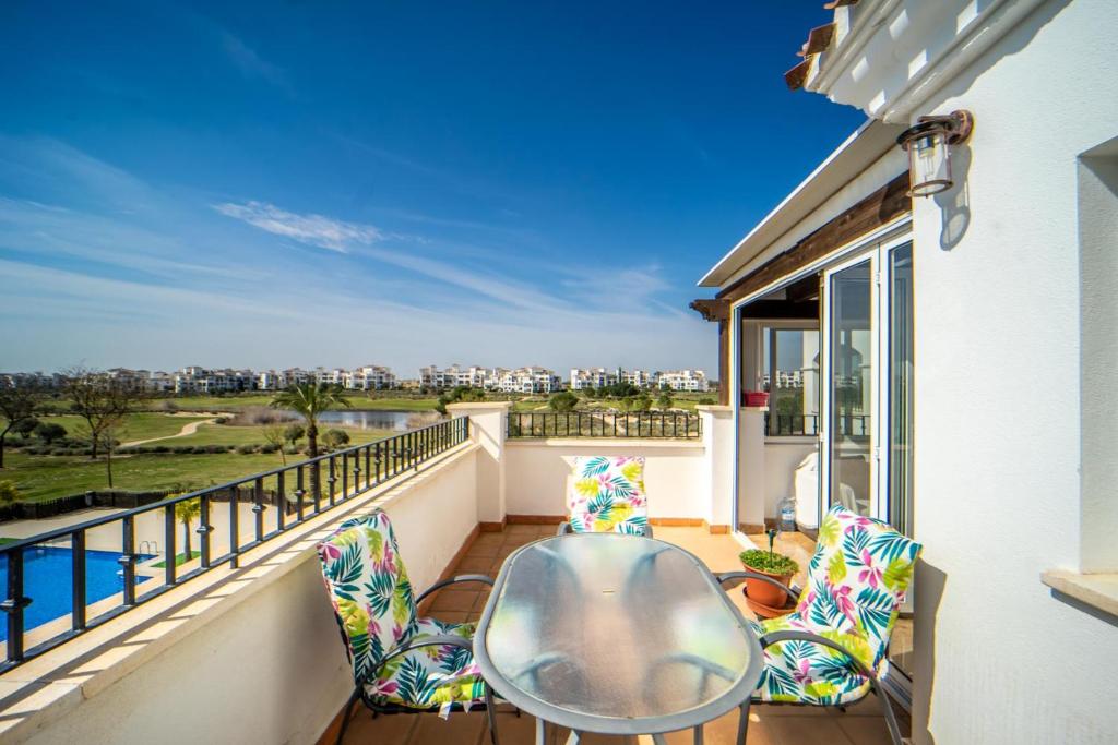 d'un balcon avec une table et des chaises offrant une vue. dans l'établissement Homely Apartment at Hacienda Riquelme Golf - IO23HR, à Sucina