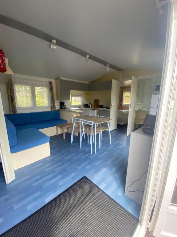 un soggiorno con tavolo e pavimento blu di domaine des planesses a Ferdrupt