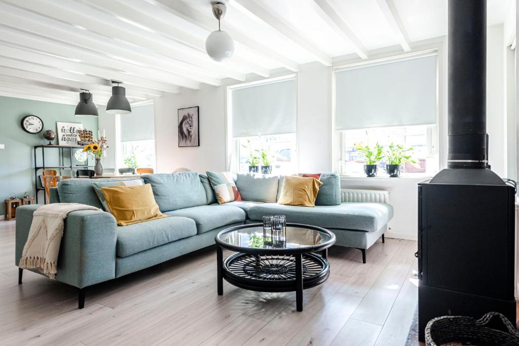 Soleil City Center Family Apartment في زاندفورت: غرفة معيشة مع أريكة زرقاء وطاولة