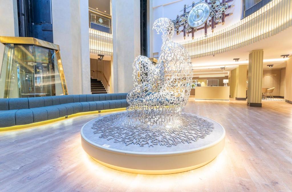 une sculpture d'une femme dans un hall dans l'établissement Grand Plaza Hotel & Wellness, à Andorre-la-Vieille