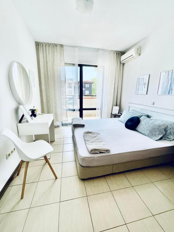 チェルノモレツにあるАпартамент в комплекс Свети Никола плаж Градинаのベッドルーム1室(ベッド1台、鏡、椅子付)
