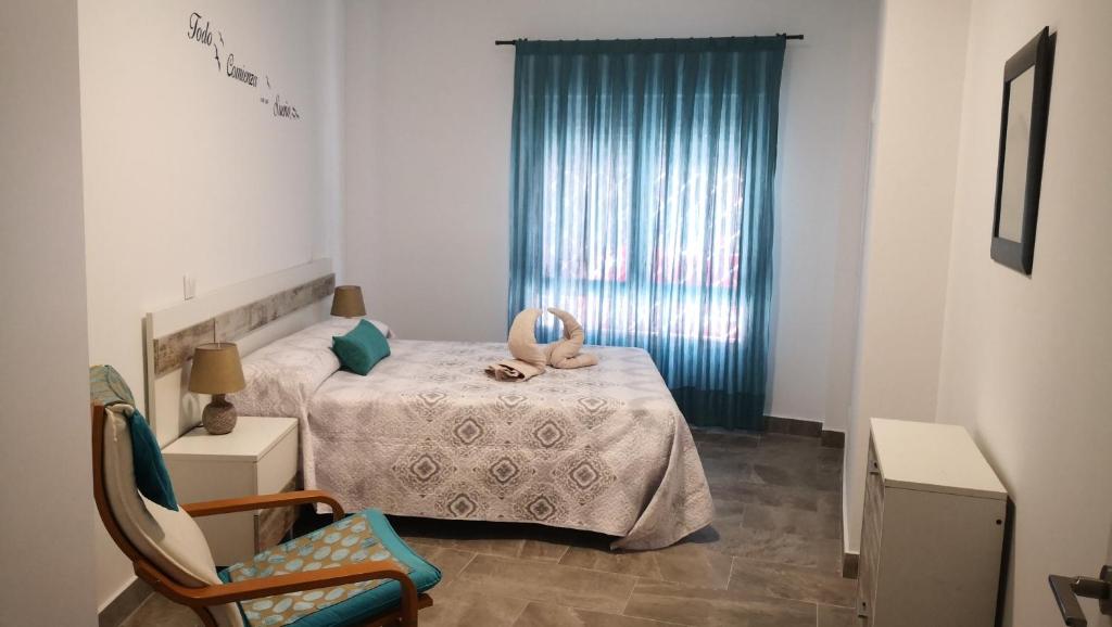 a bedroom with a bed and a chair and a window at Apartamento La Galatea in Alcalá de Henares