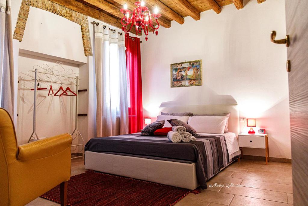 een slaapkamer met een bed en een kroonluchter bij Sole e Vento in Chioggia
