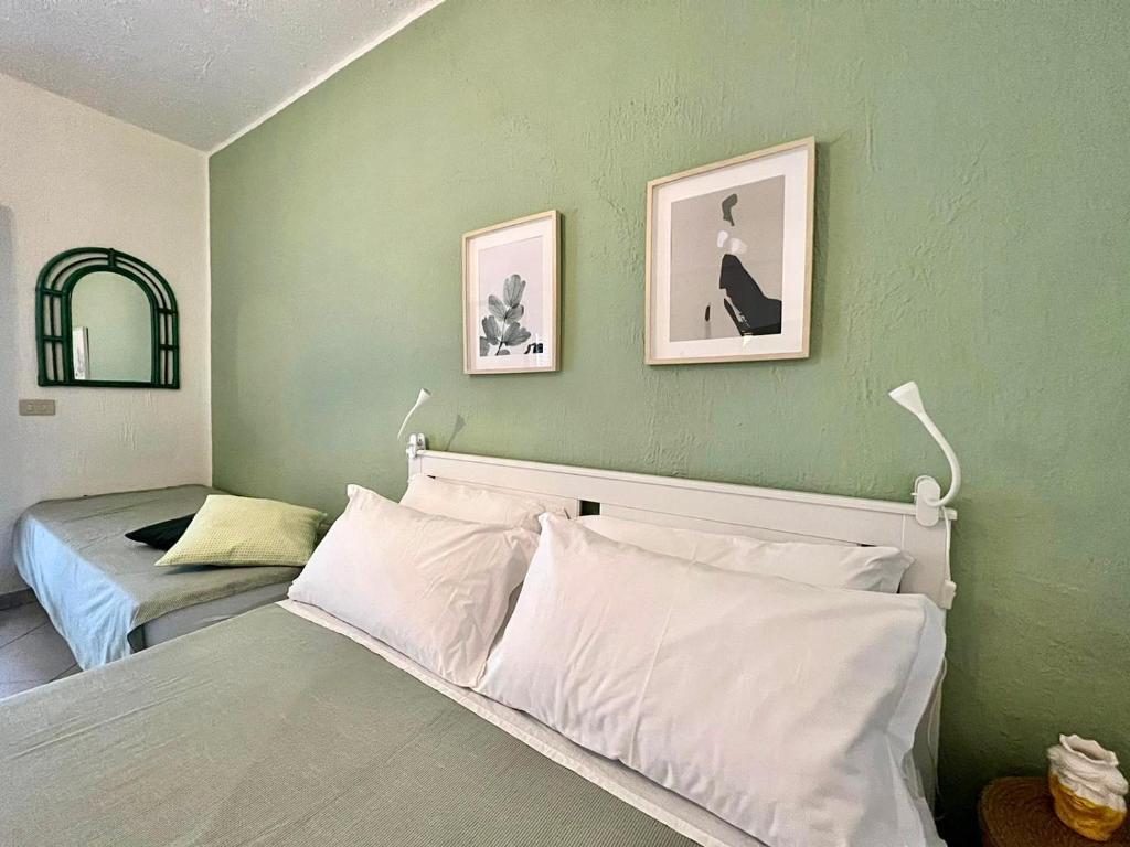 een slaapkamer met twee bedden en twee foto's aan de muur bij Baia degli Dei - Living La Nike in Giardini Naxos
