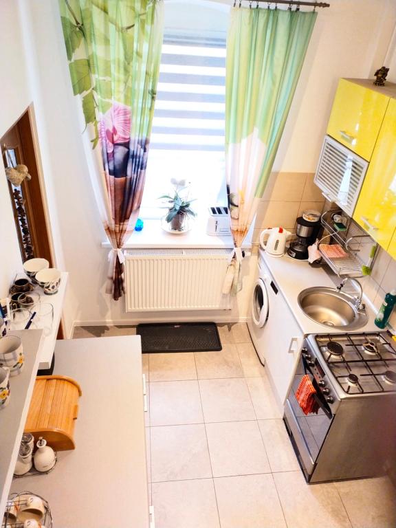 a small kitchen with a stove and a window at Przy Rynku in Duszniki Zdrój