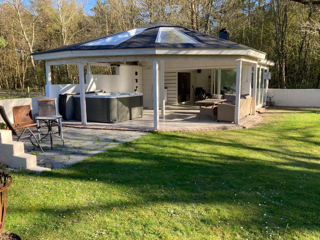 a gazebo with a table and chairs in a yard at Davidslids cottage in Löddeköpinge