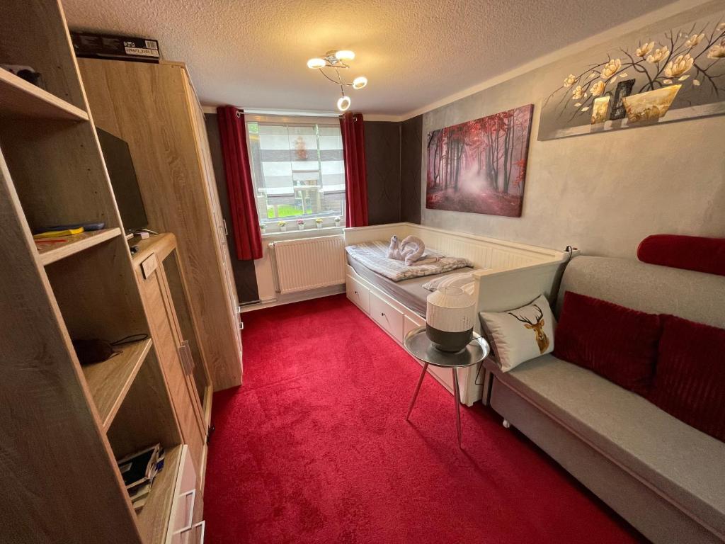 een kamer met een rode vloer, een bed en een raam bij Tiny House in Burig