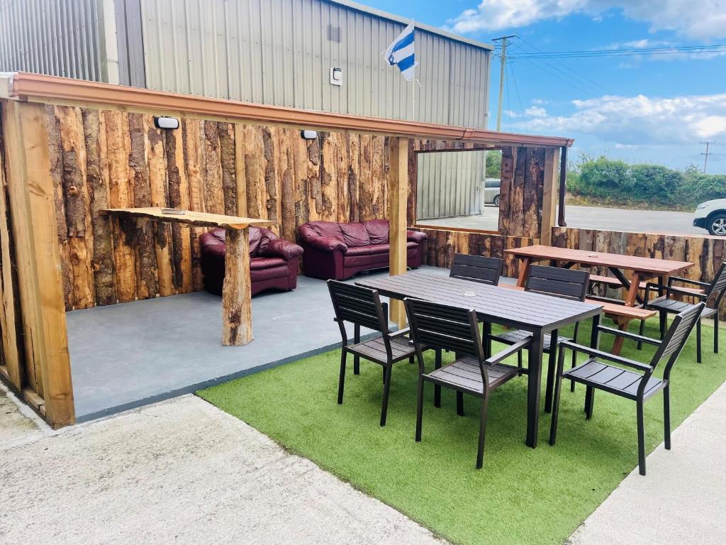 a patio with a table and chairs on grass at Greenway & Copper Coast Hostel in Bunmahon