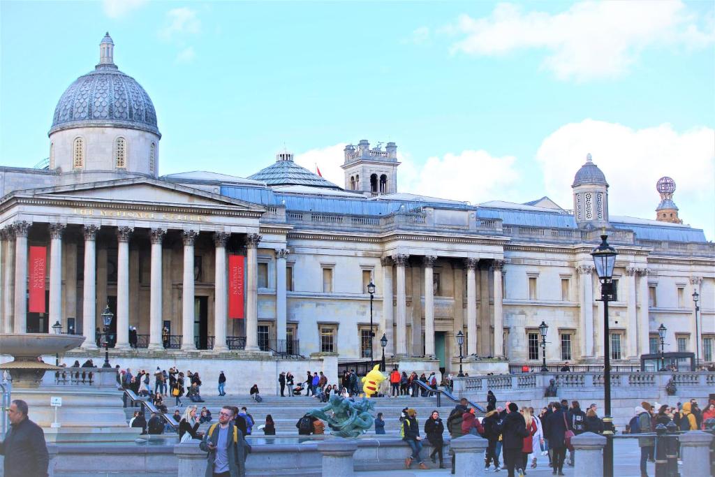 ein großes Gebäude mit Leuten, die davor laufen in der Unterkunft The Z Hotel Trafalgar in London