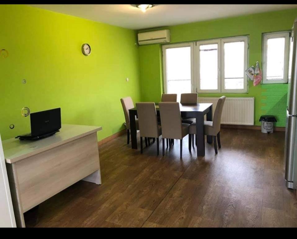 a dining room with green walls and a table and chairs at Greenspace in Niš