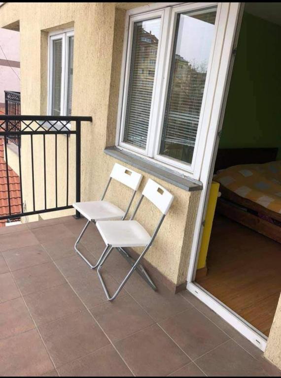 a white chair sitting on a porch next to a window at Greenspace in Niš