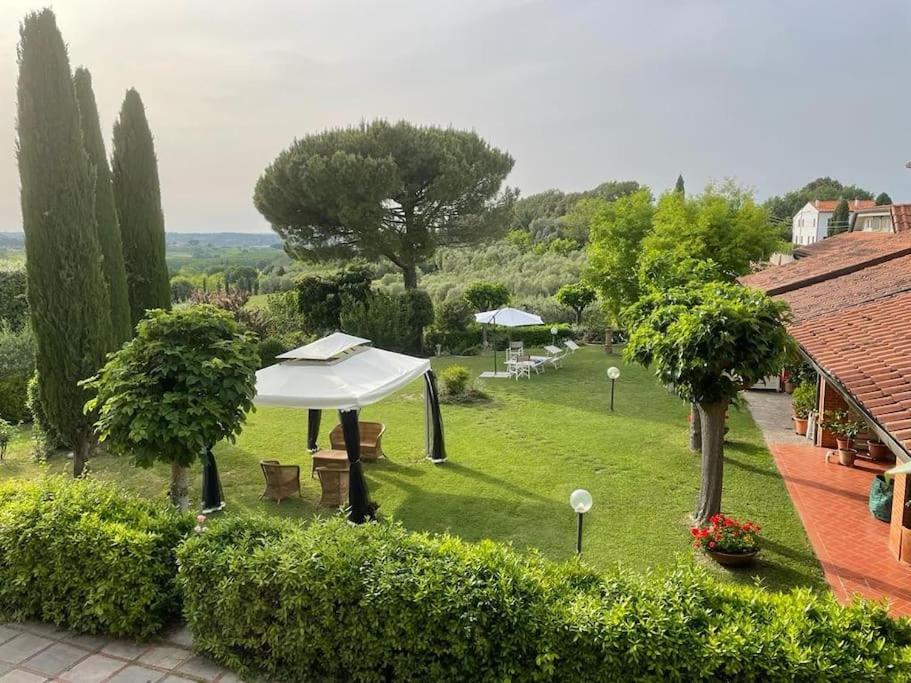 ein Bild eines Gartens mit einem weißen Regenschirm in der Unterkunft Casa vacanze Gemma Toscana in Capannoli