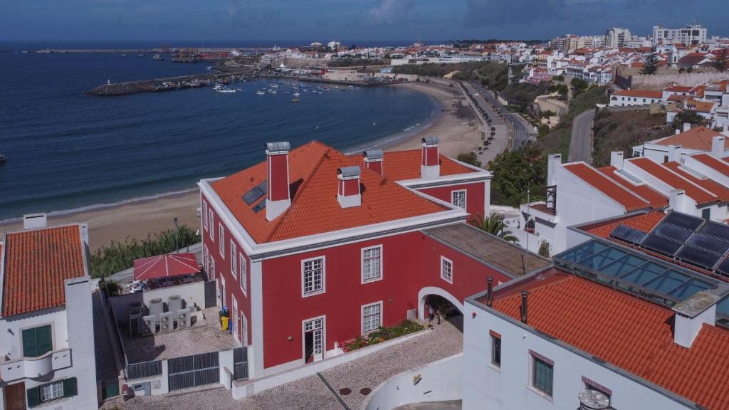 an aerial view of a red building and a beach at Casa do Médico de São Rafael in Sines